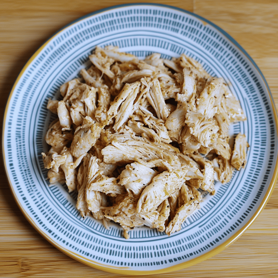 Shredded Chicken for Frank’s Buffalo Chicken Dip Plate of seasoned shredded chicken breast ready for Frank’s Buffalo Chicken Dip recipe.