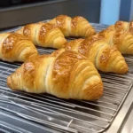 Gipfeli Recipe – A Taste of Swiss Tradition 2 Freshly baked Gipfeli pastries on a wire rack – perfect result from this traditional Gipfeli recipe