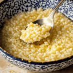 Simple Italian Pastina Soup – A Comforting Classic 2 Creamy cooked pastina soup in a decorative blue and white bowl with a spoonful lifted