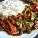 Easy Pepper Steak Recipe – A Classic American Comfort Dish 2 Pepper steak with red and green bell peppers, onions, and sauce served with steamed rice