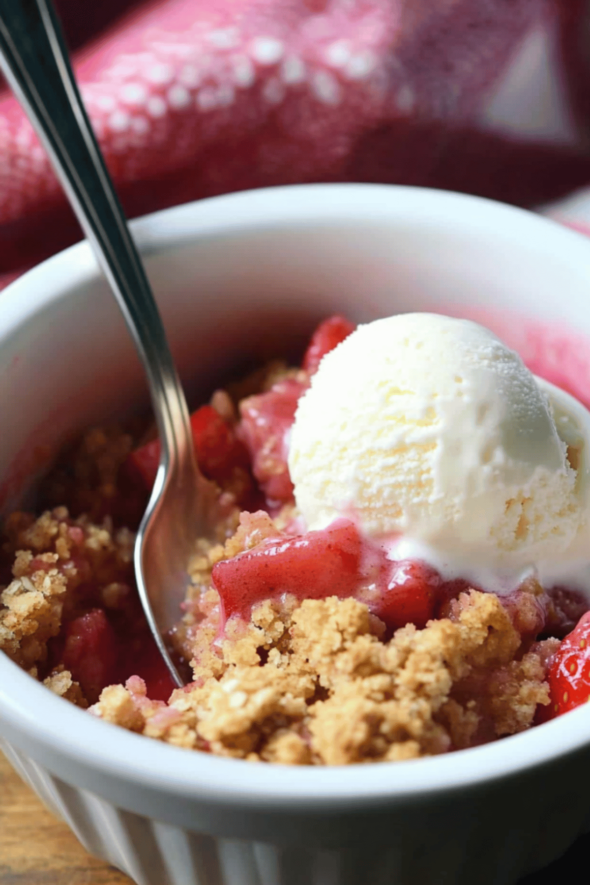 Strawberry Rhubarb Crumble with Ice Cream Strawberry rhubarb crumble served in a white bowl with vanilla ice cream