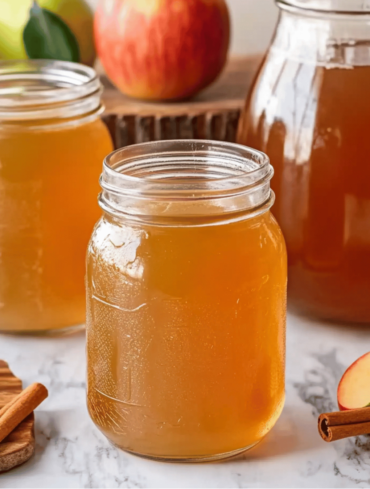 jar of apple pie moonshine with apples and cinnamon
