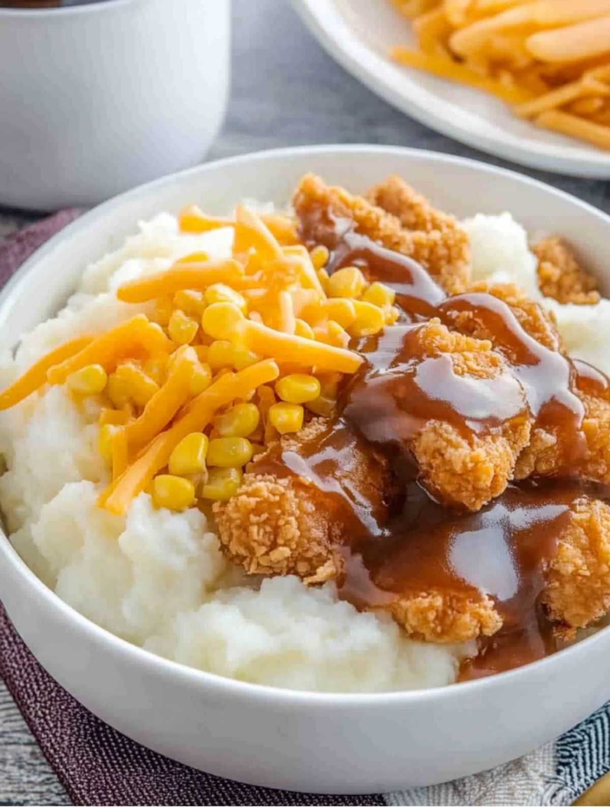 Cheesy Homemade KFC Bowl with Popcorn Chicken Classic KFC bowl with mashed potatoes, crispy chicken, melted cheese, and corn