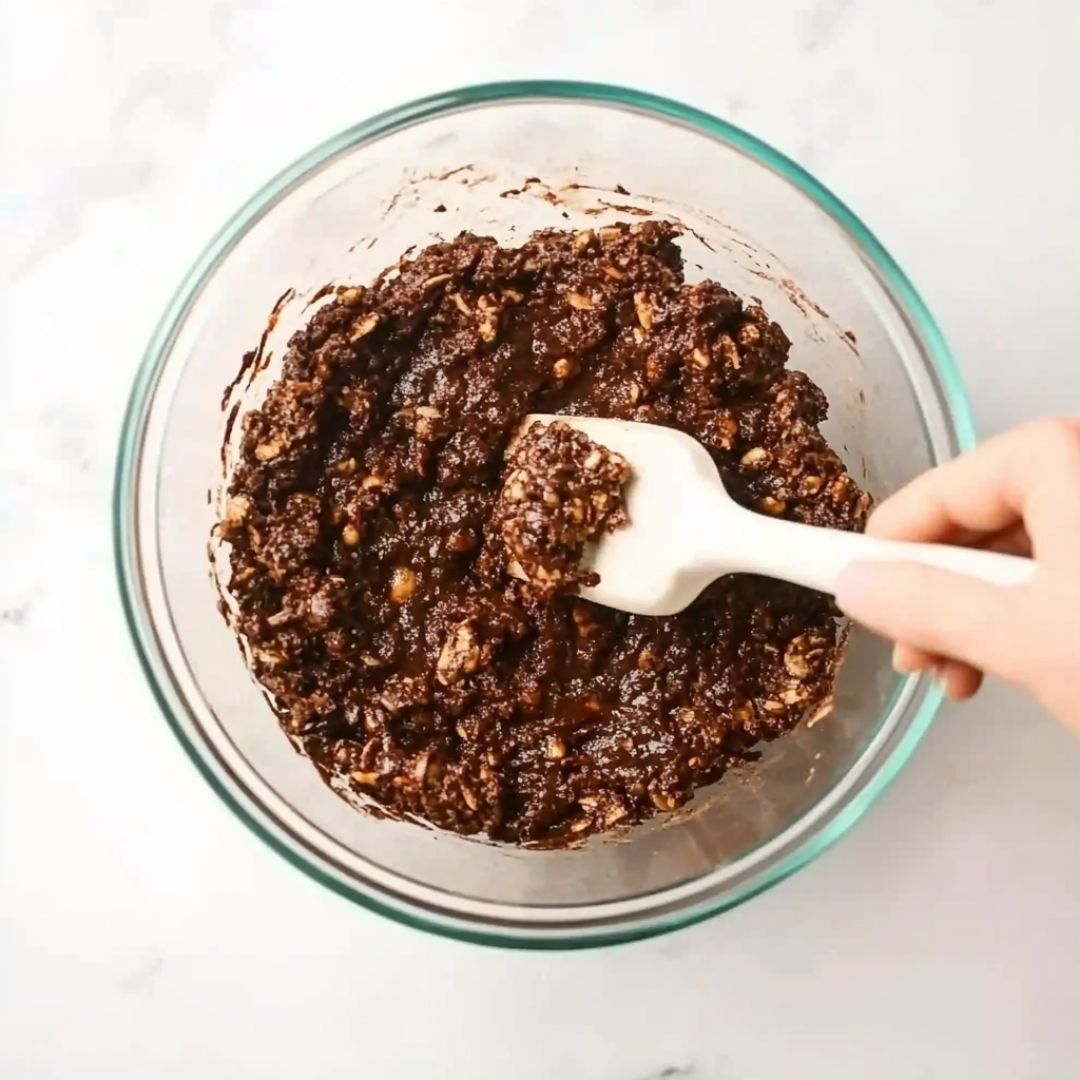 No Bake Protein Cookie Dough Preparation Mixing chocolate oat dough for no bake protein cookies in a glass bowl