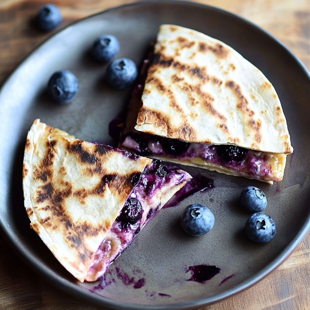Blueberry Quesadilla Triangles on Ceramic Plate Triangular quesadilla slices filled with blueberries