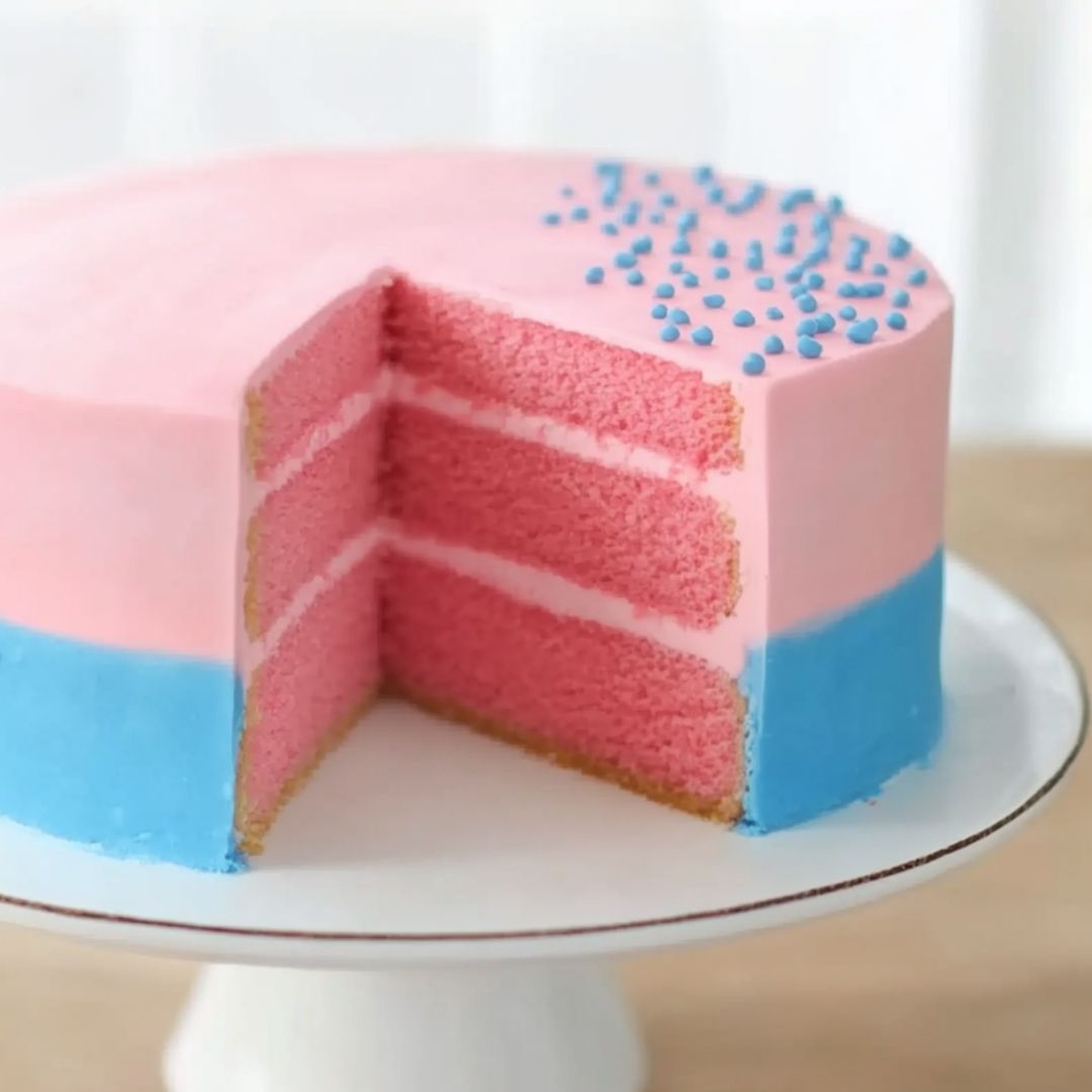 Sliced Gender Reveal Cake with Bright Pink Interior Gender reveal cake sliced to reveal pink sponge inside